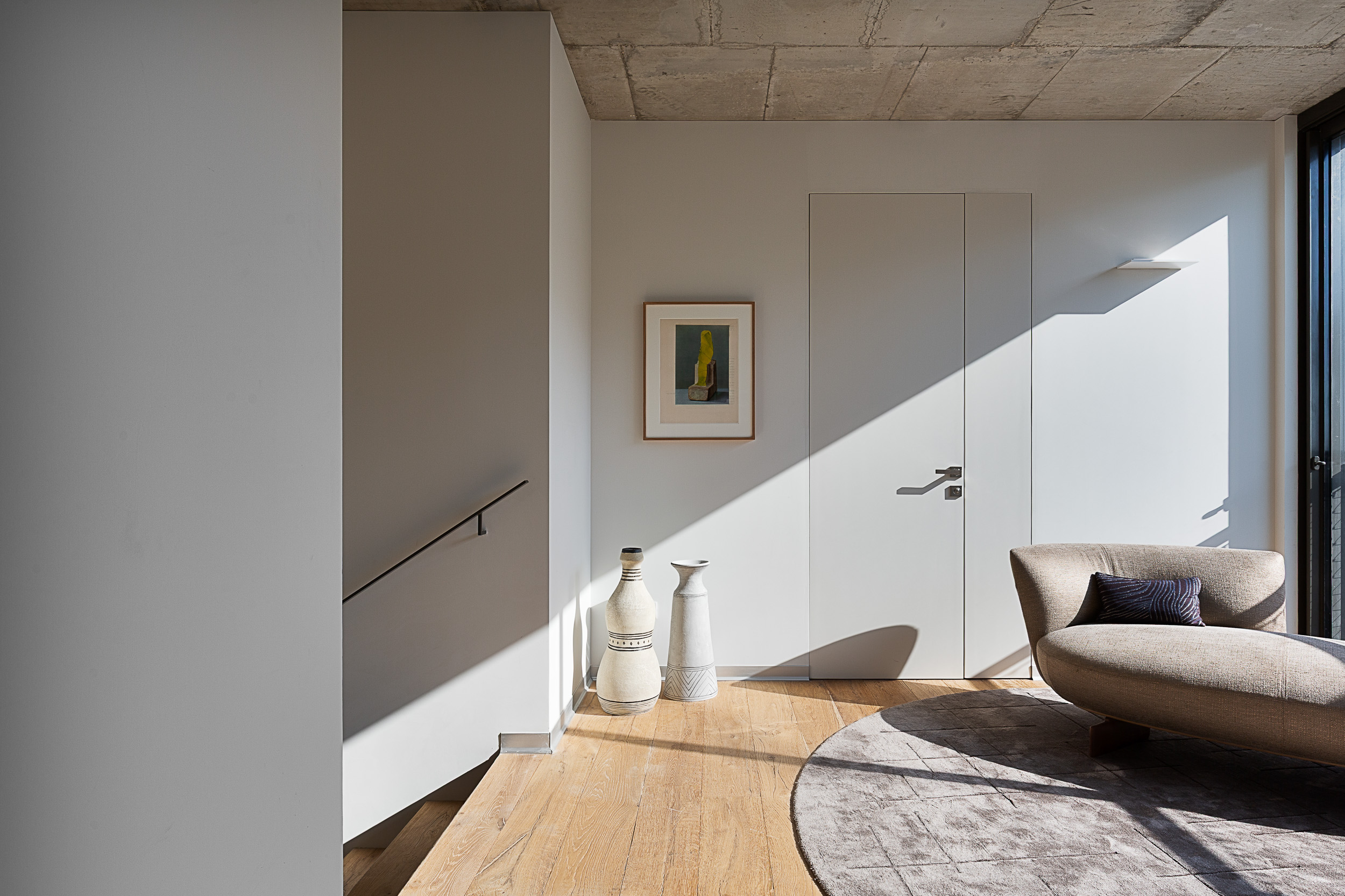 צילום אדריכלות ועיצוב פנים למסדרון וגרם מדרגות עם משחקי אור וצל טבעי בדירות הלווי (The Levee) תל אביב. צילום: עידן סעידי | Professional architectural photography of a hallway and staircase featuring natural shadow play at The Levee, Tel Aviv. Photo: Idan Saidi.